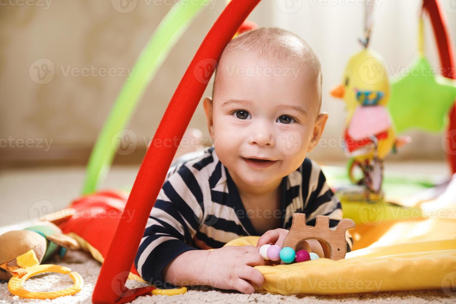 Cute baby is playing on the activity mat 16249514 Stock Photo at Vecteezy