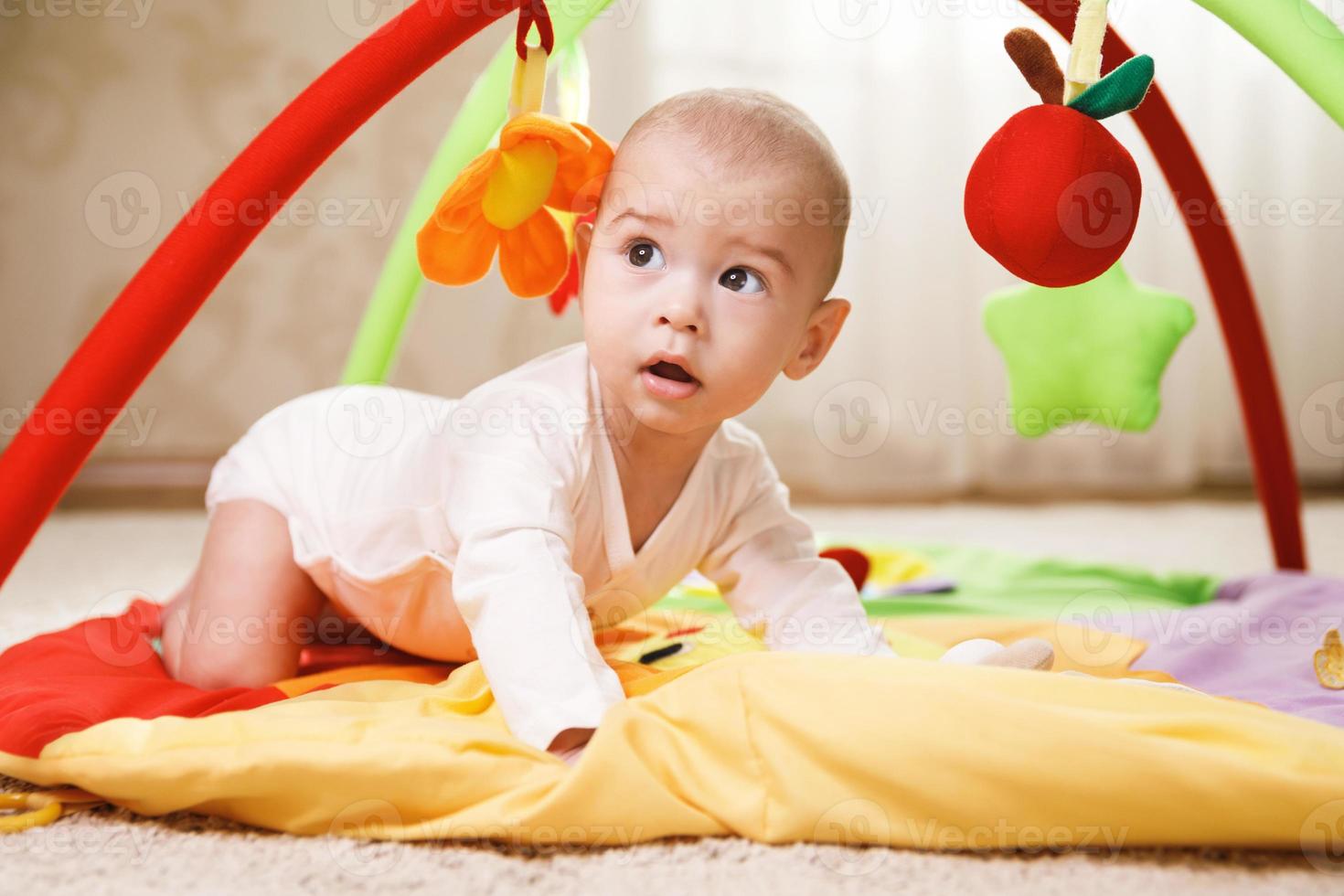Cute baby is playing on the activity mat photo