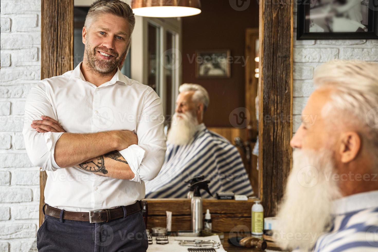 Happy hairdresser and client in the barbershop photo