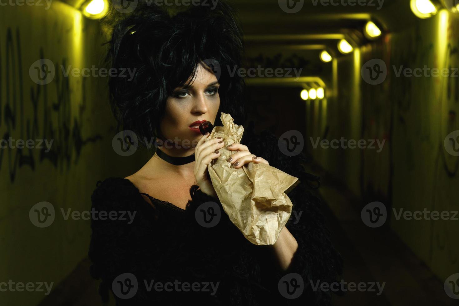 Freaky woman with a bottle of alcohol in the paper bag photo