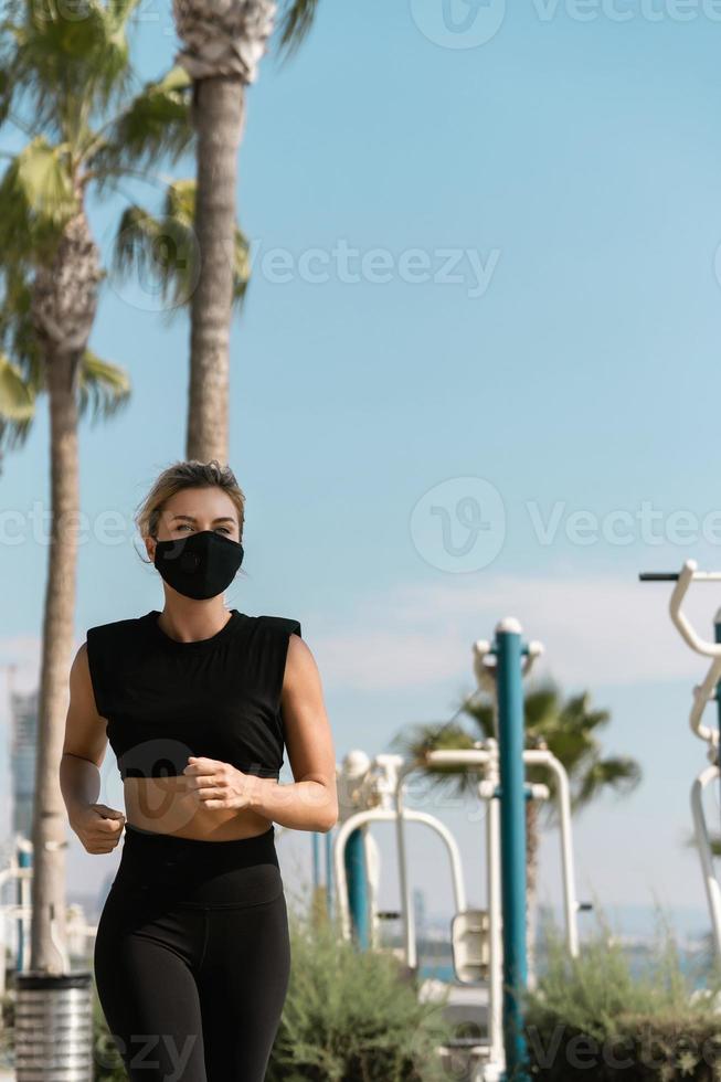 Athletic woman wearing face mask is running during her summer jogging