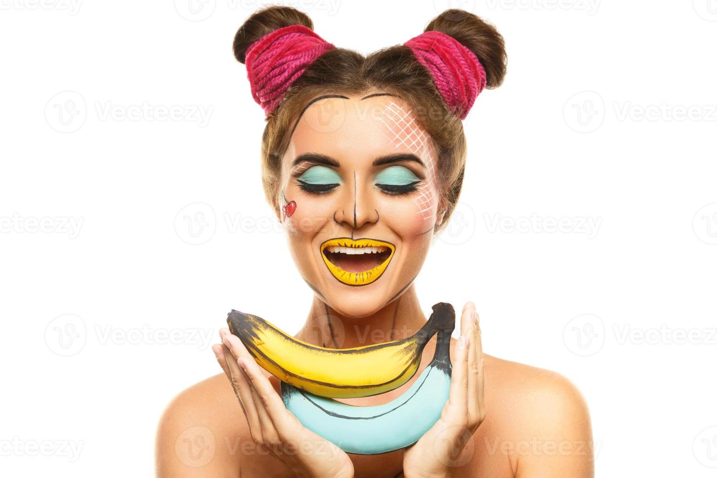 Beautiful model with creative pop art makeup holding bananas photo