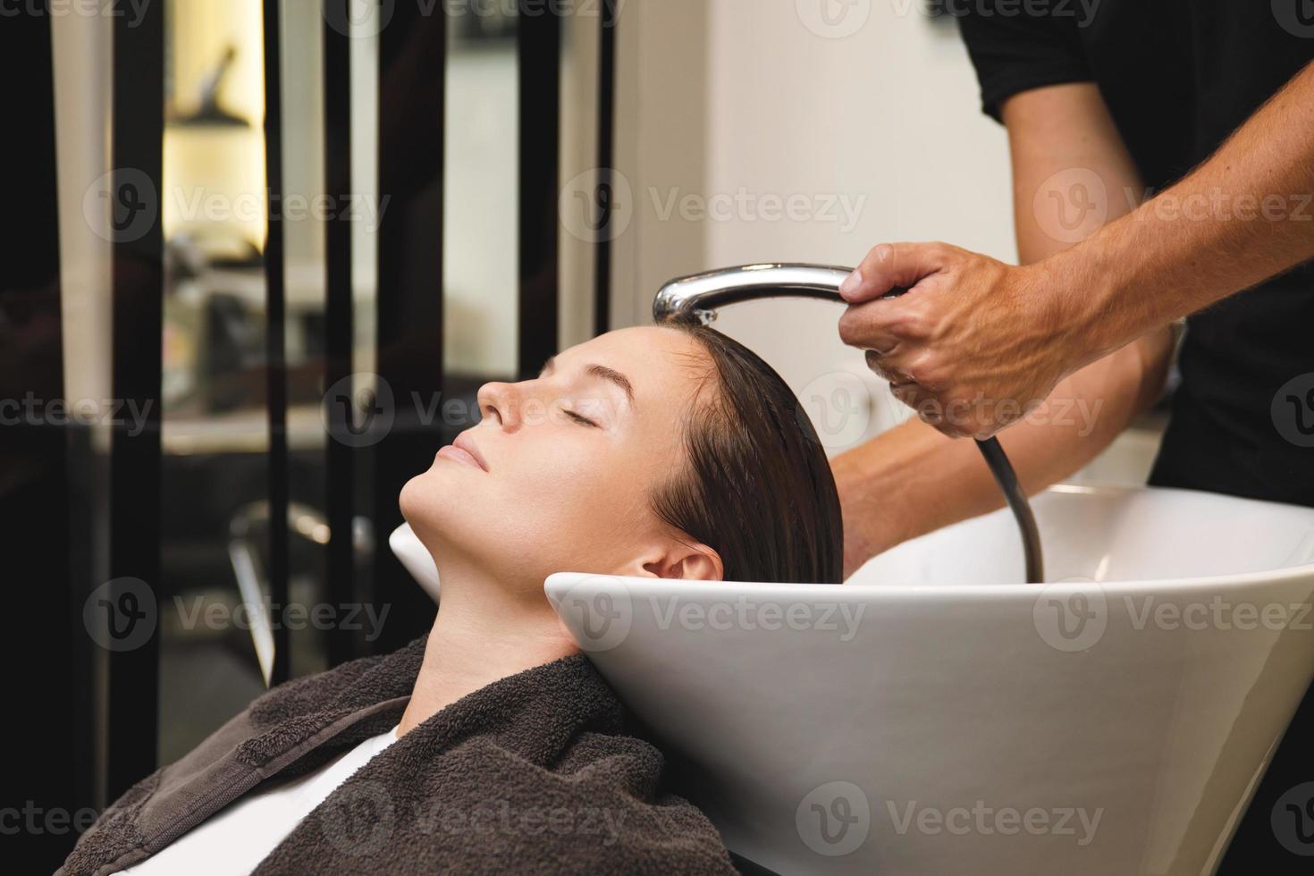 Woman in hairdresser salon during hair wash after haircut photo