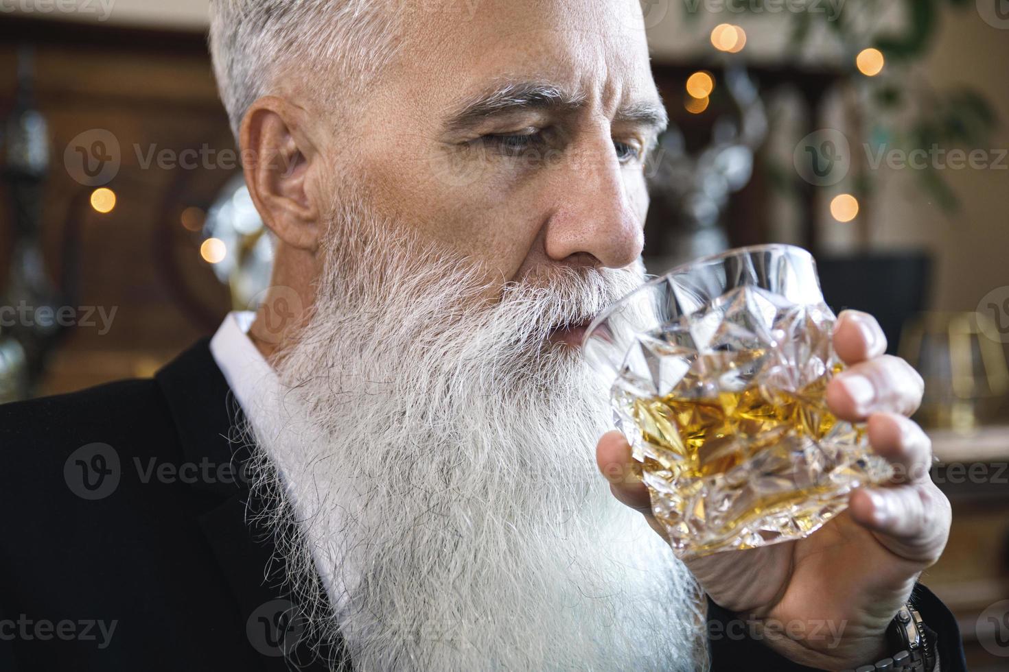 Handsome bearded senior man with a glass of whiskey photo