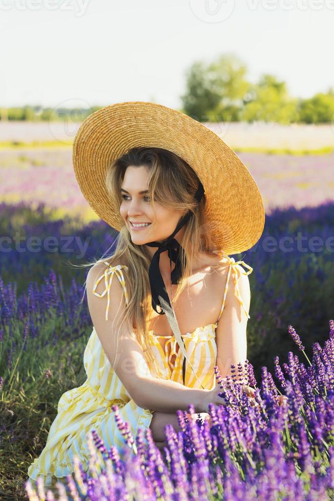 Beautiful young woman in a field full of lavender flowers photo