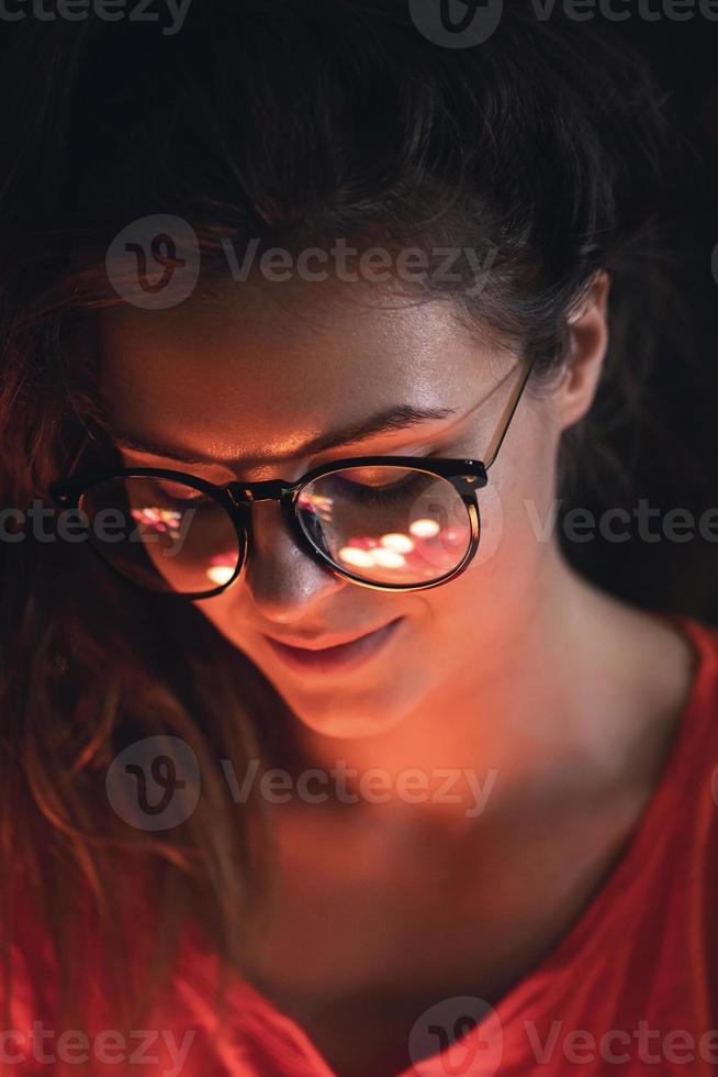 Young woman with reflection of glowing light balls in her eye glasses photo