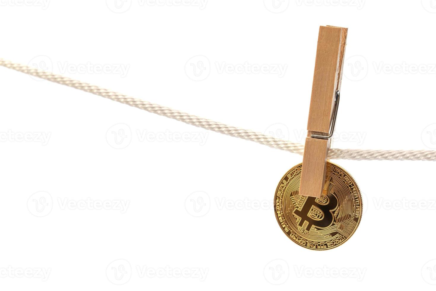 Bitcoin is hung on a rope with clothespins. photo