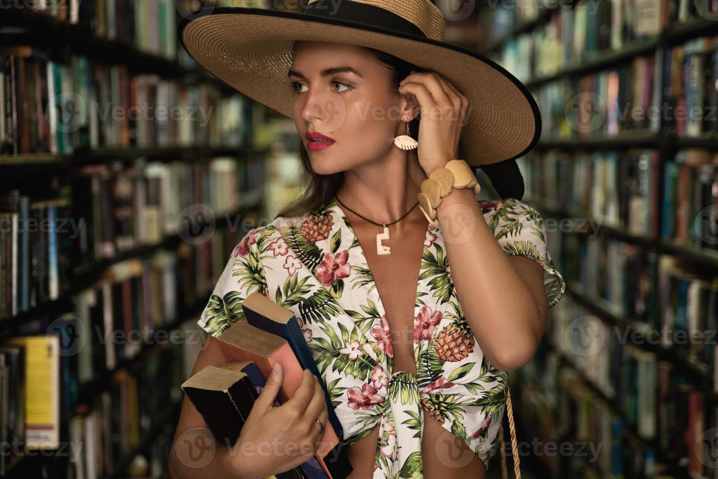 Beautiful girl wearing stylish outfit looking for interesting book in the vintage bookstore photo
