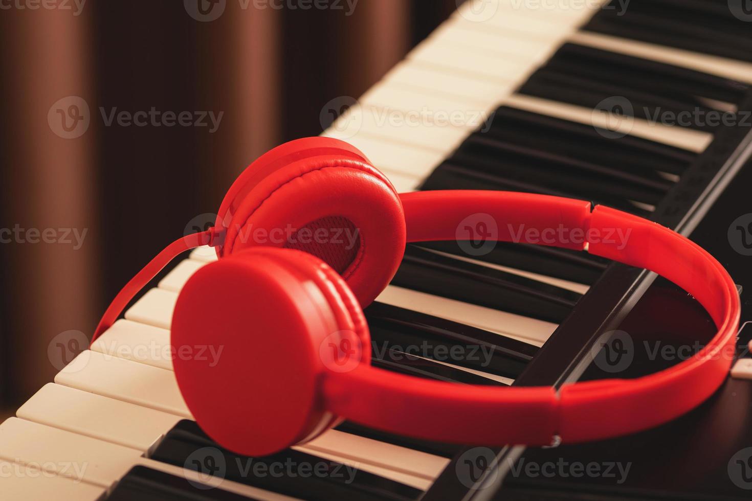 Closeup of red headphones over synthesizer keyboard photo