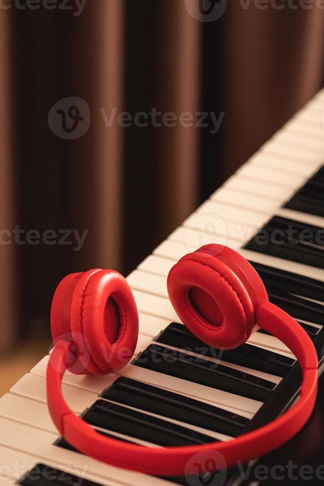 Closeup of red headphones over synthesizer keyboard photo