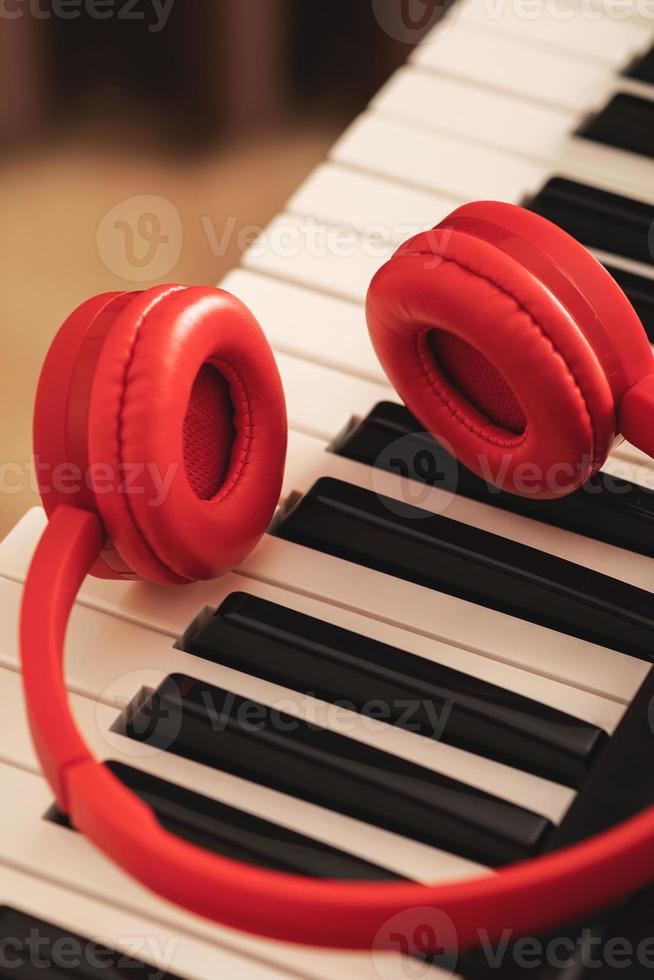 Closeup of red headphones over synthesizer keyboard photo