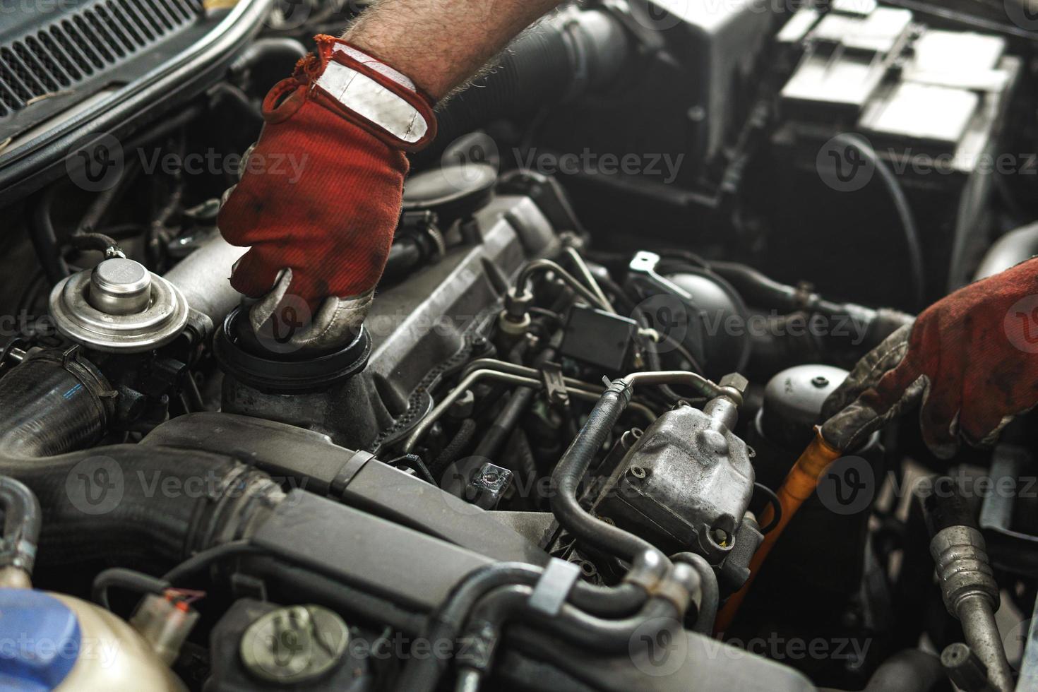 Mechanic inspecting car in the automobile repair shop photo