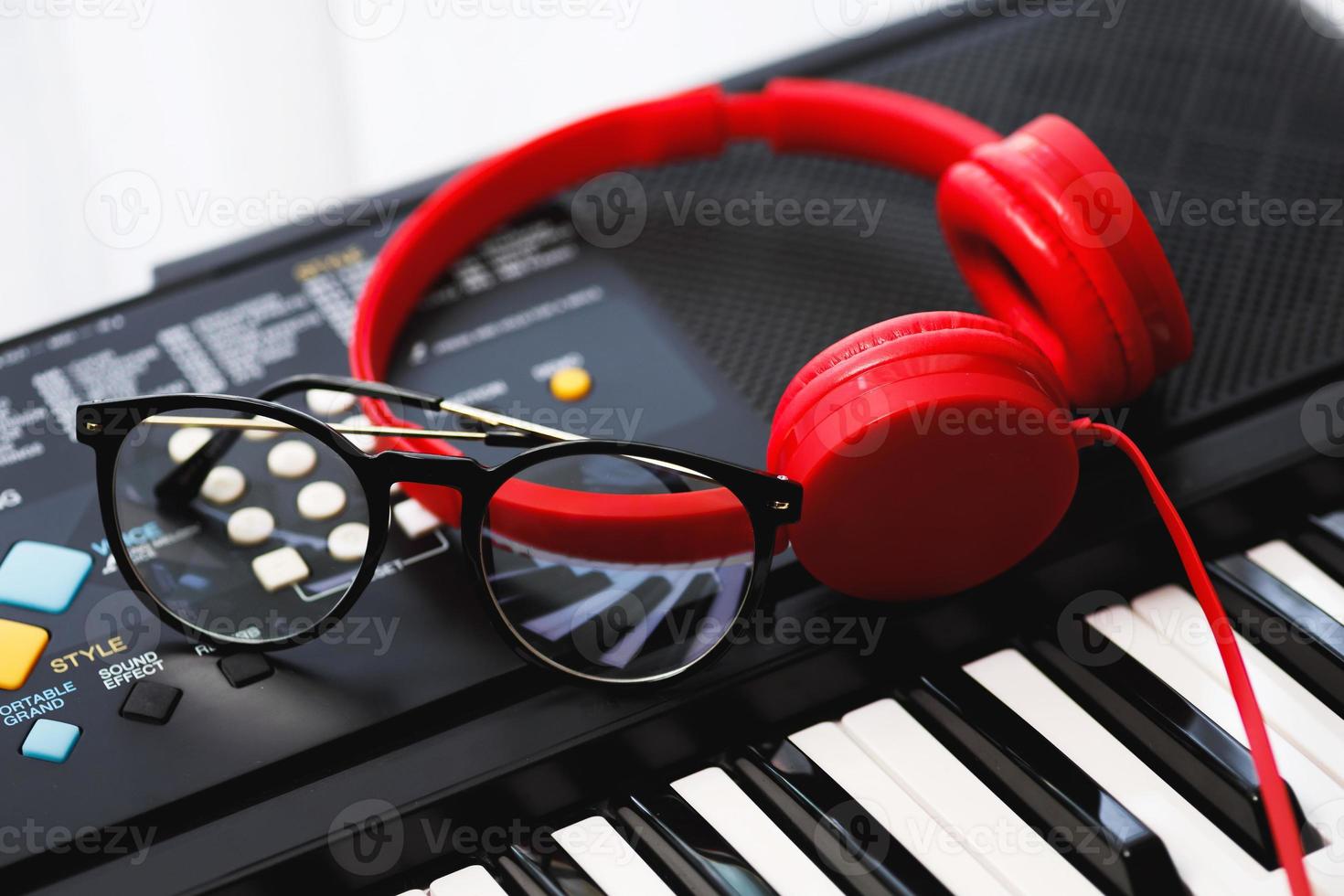 auriculares rojos y anteojos en el teclado del sintetizador foto