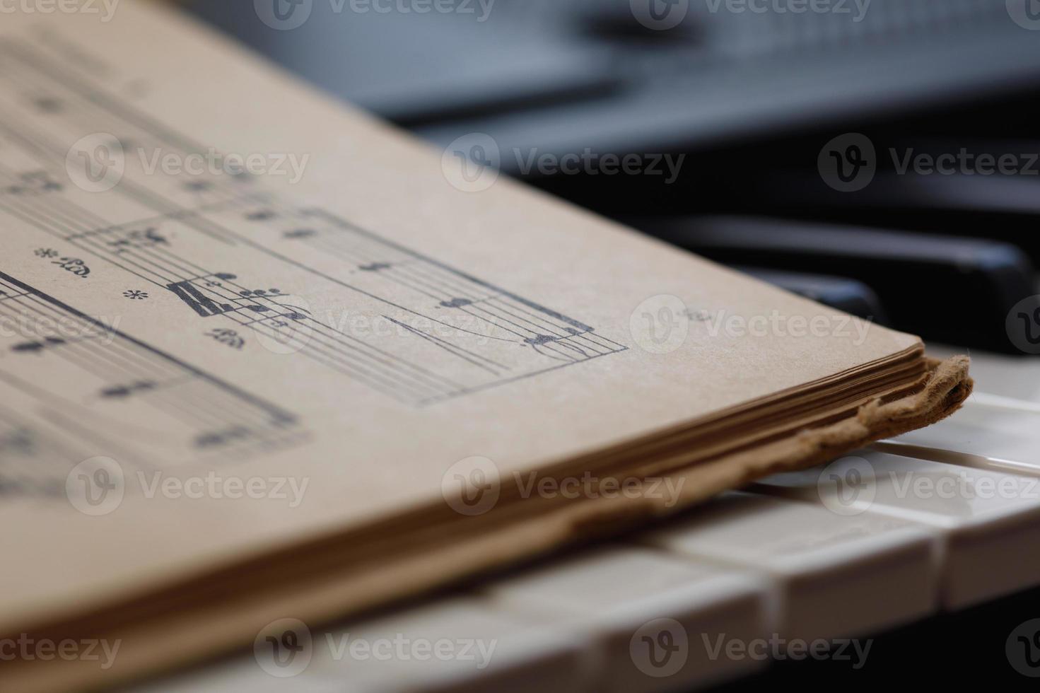 Close up of sheet music on the piano keys photo