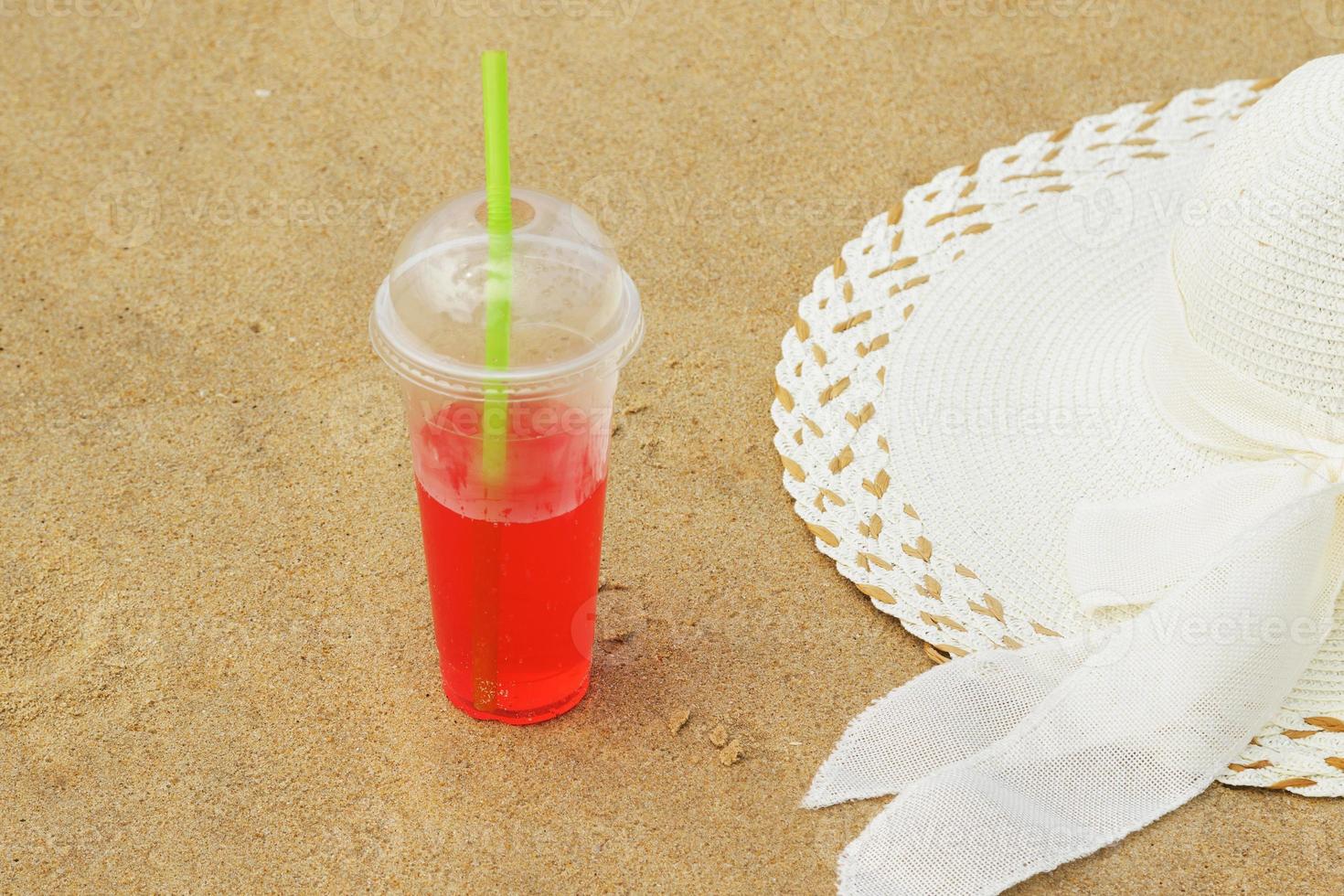 Plastic cup with a red refreshment drink and the broad brim hat photo