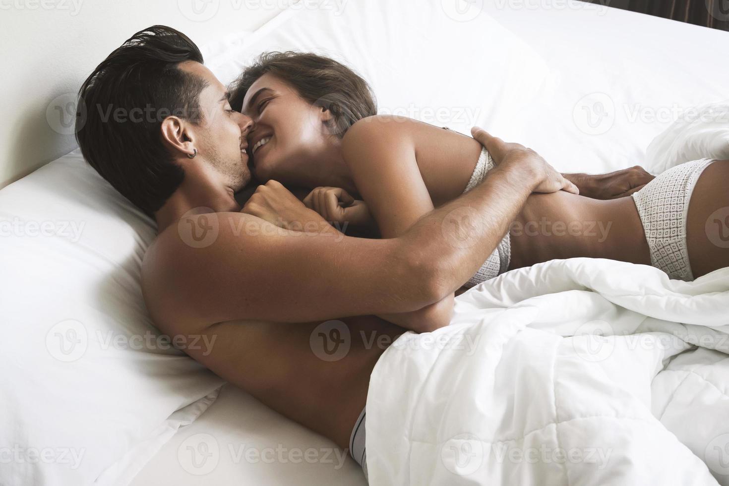 hermosa pareja en un abrazo acostado en la cama foto