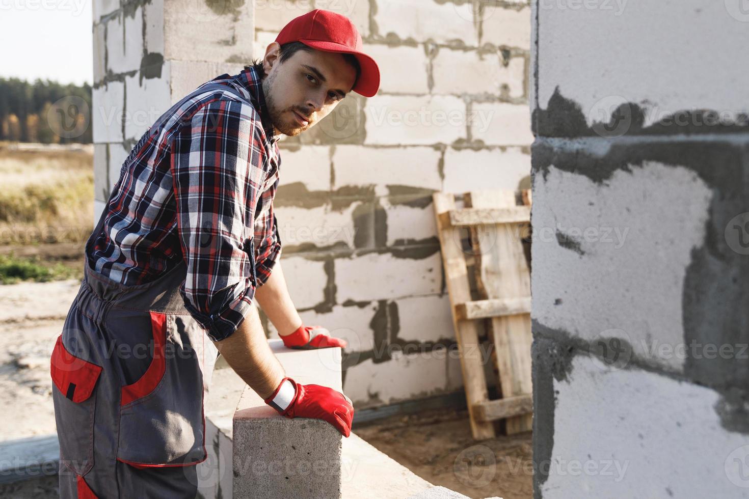 Bricklayer is working at the construction site photo