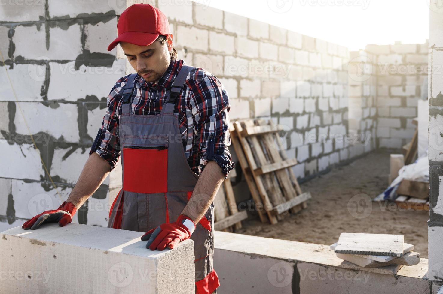 Bricklayer is working at the construction site photo