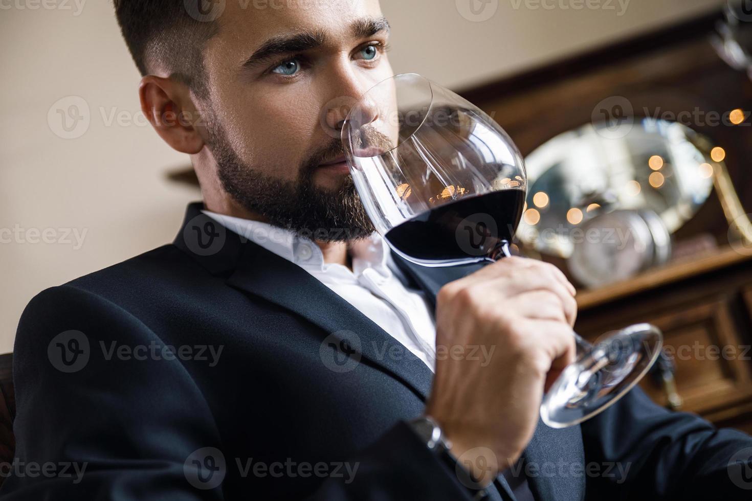 Handsome bearded man with a glass of red wine photo