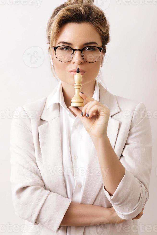 Smart businesswoman holding chess figure in her hand photo