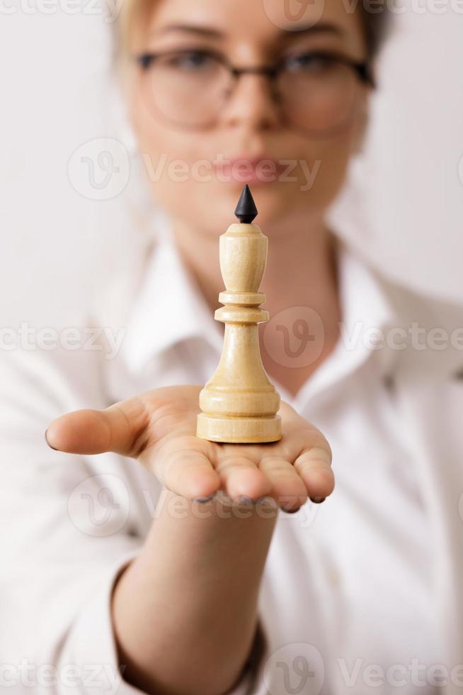 Smart businesswoman holding chess figure in her hand photo