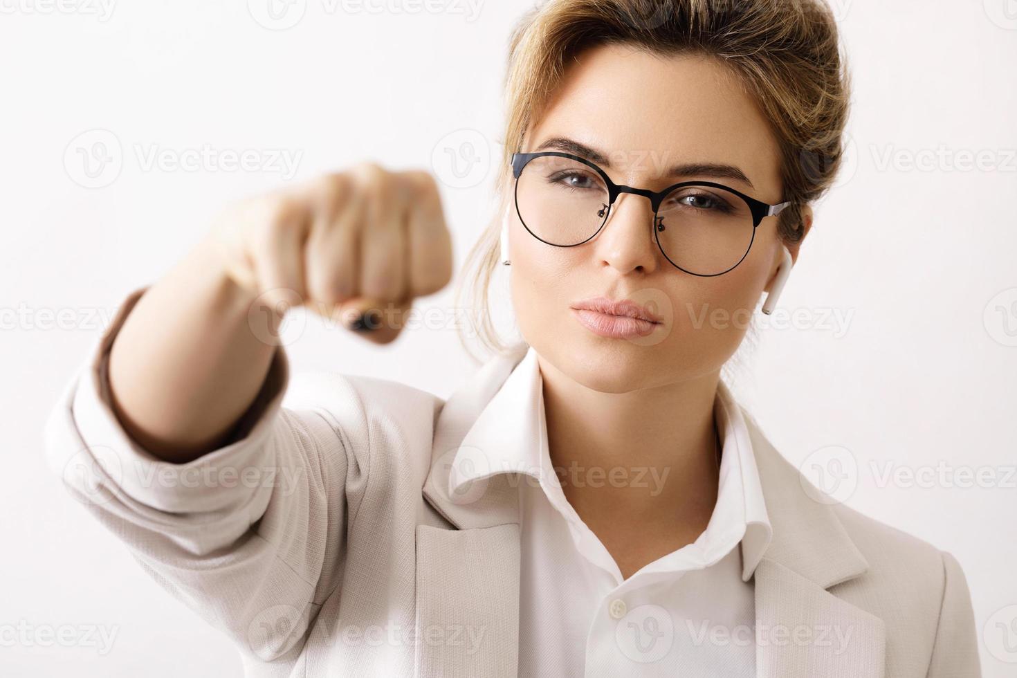 Confident business woman make a punch into the camera photo