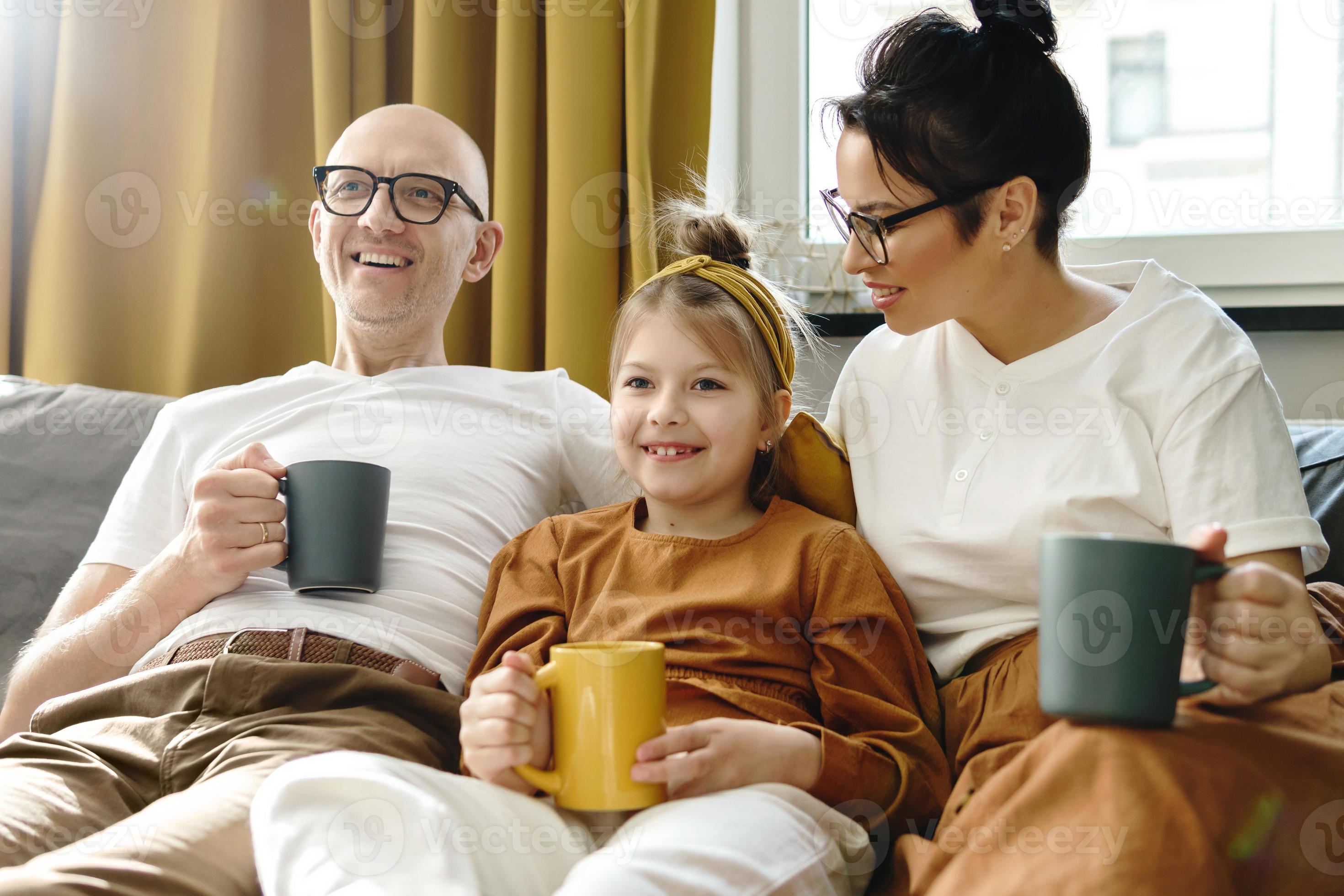 happy-family-relaxing-on-a-the-sofa-and-drinking-hot-tea-16251909-stock