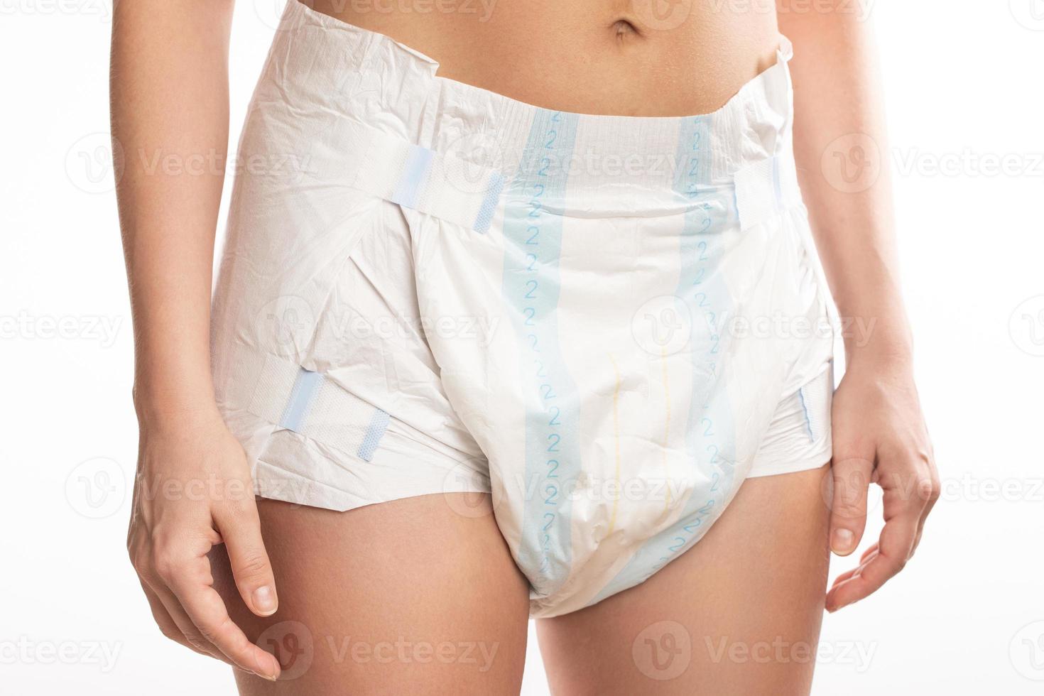 Woman wearing adult diaper against white background. photo
