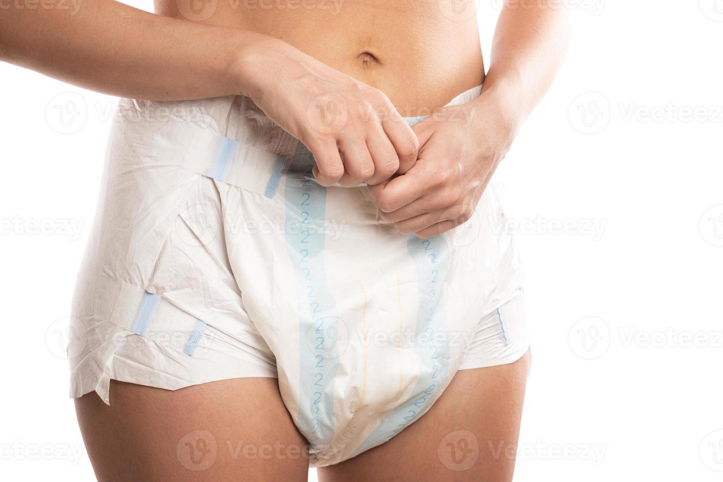 Woman wearing adult diaper against white background. photo