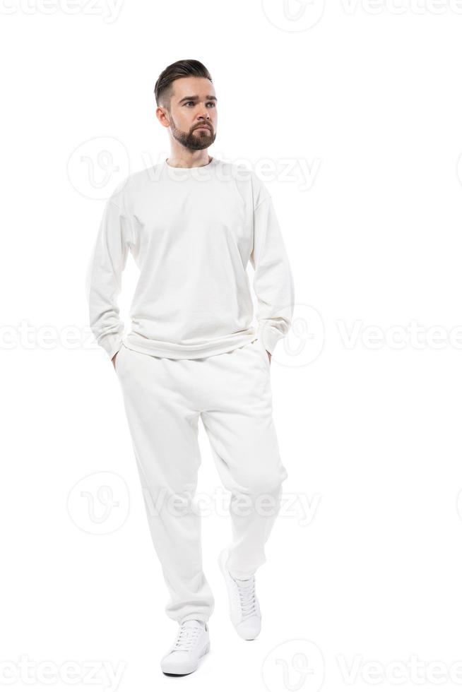 hombre guapo con camiseta blanca de manga larga y pantalones de fondo blanco foto