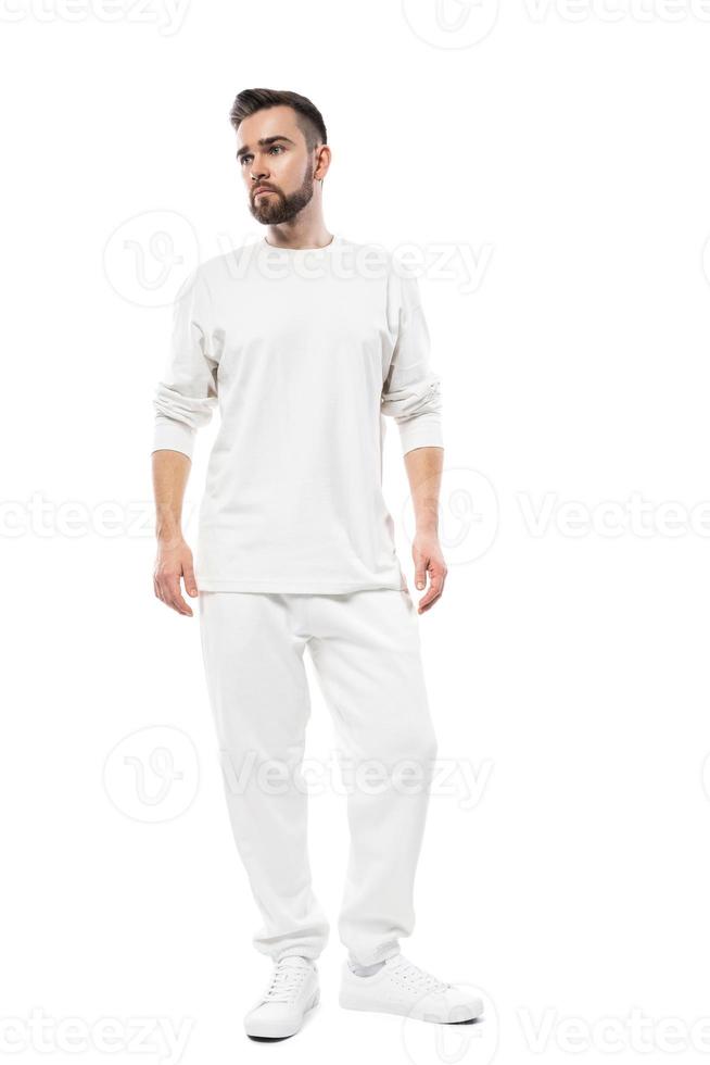 hombre guapo con camiseta blanca de manga larga y pantalones de fondo blanco foto