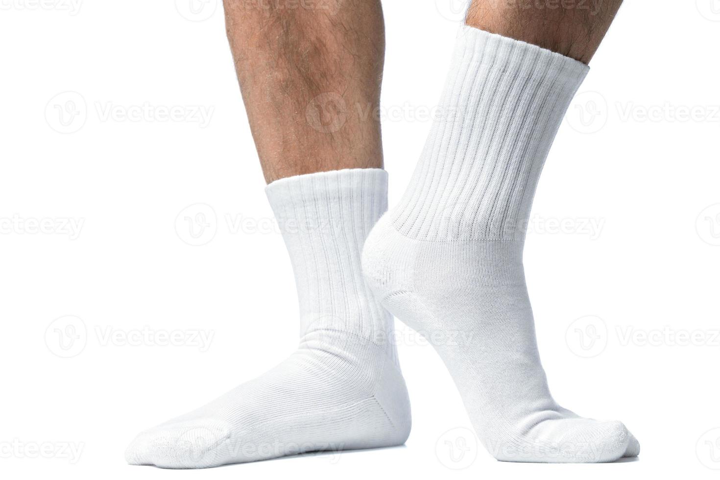 Male feet with white cotton socks on white background photo