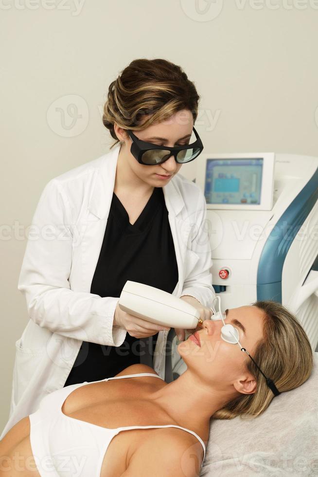 cliente mujer durante el tratamiento ipl en una clínica de cosmetología foto