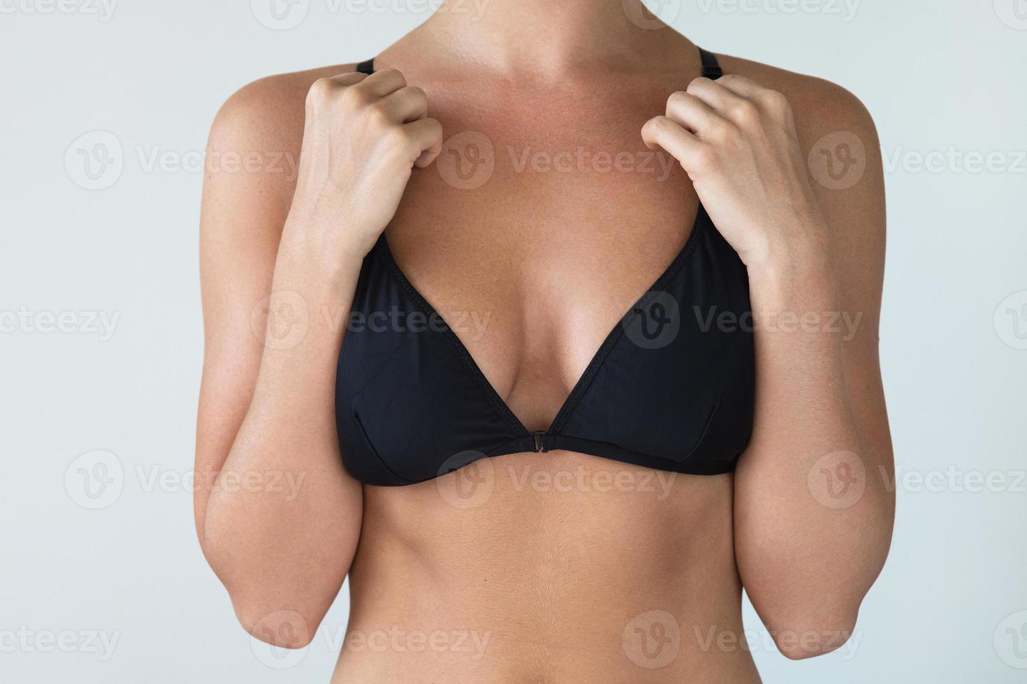 Woman with natural breast wearing black swimwear top photo