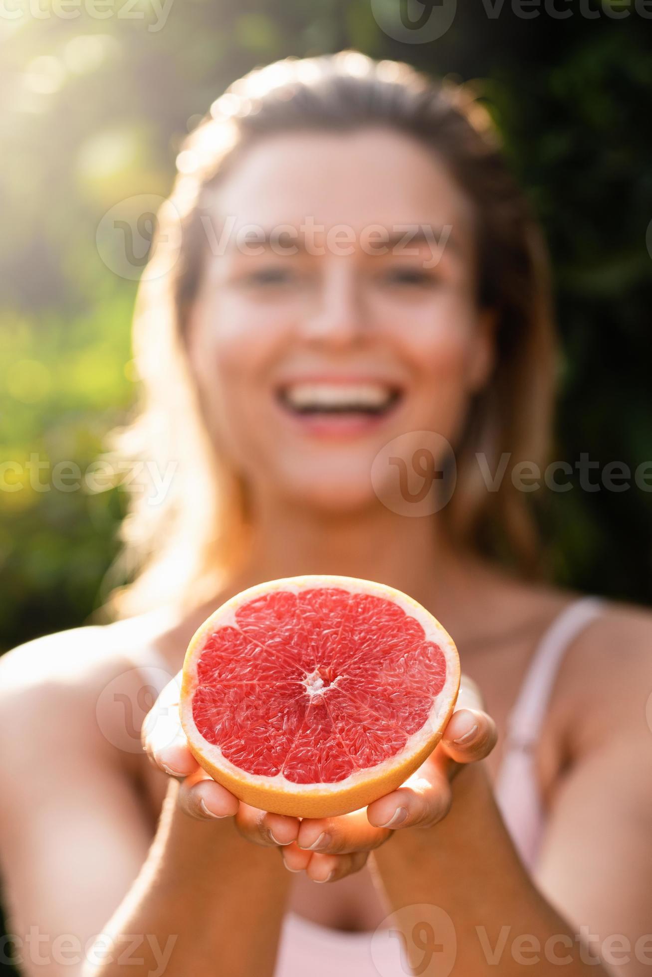 Beautiful woman with smooth skin with a grapefruit in her hands