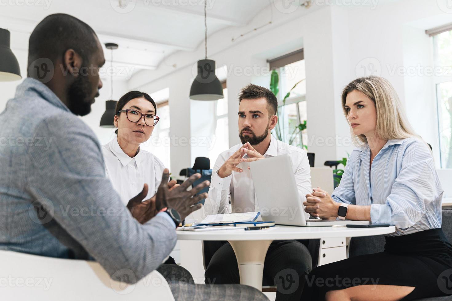 empresarios multiétnicos durante una reunión en una oficina moderna foto