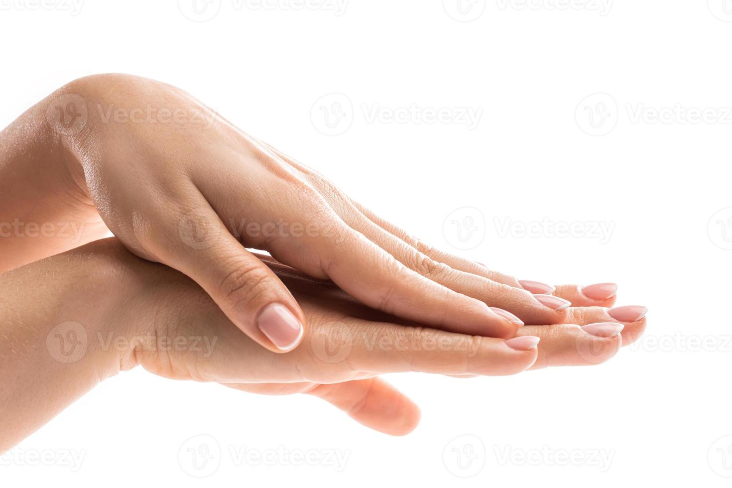 Female hands with soft skin and beautiful french manicure on white background photo