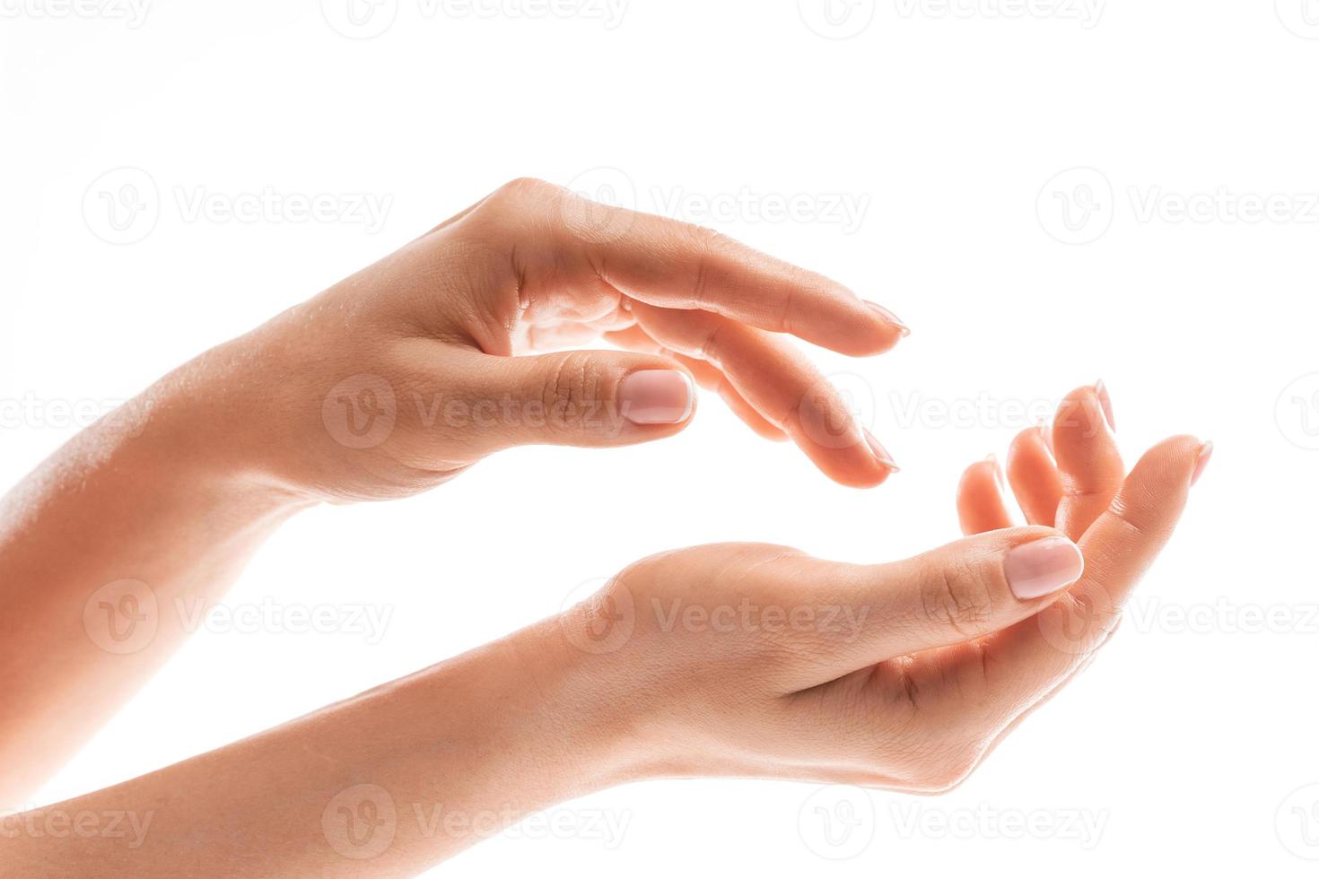 Female hands with soft skin and beautiful french manicure on white background photo