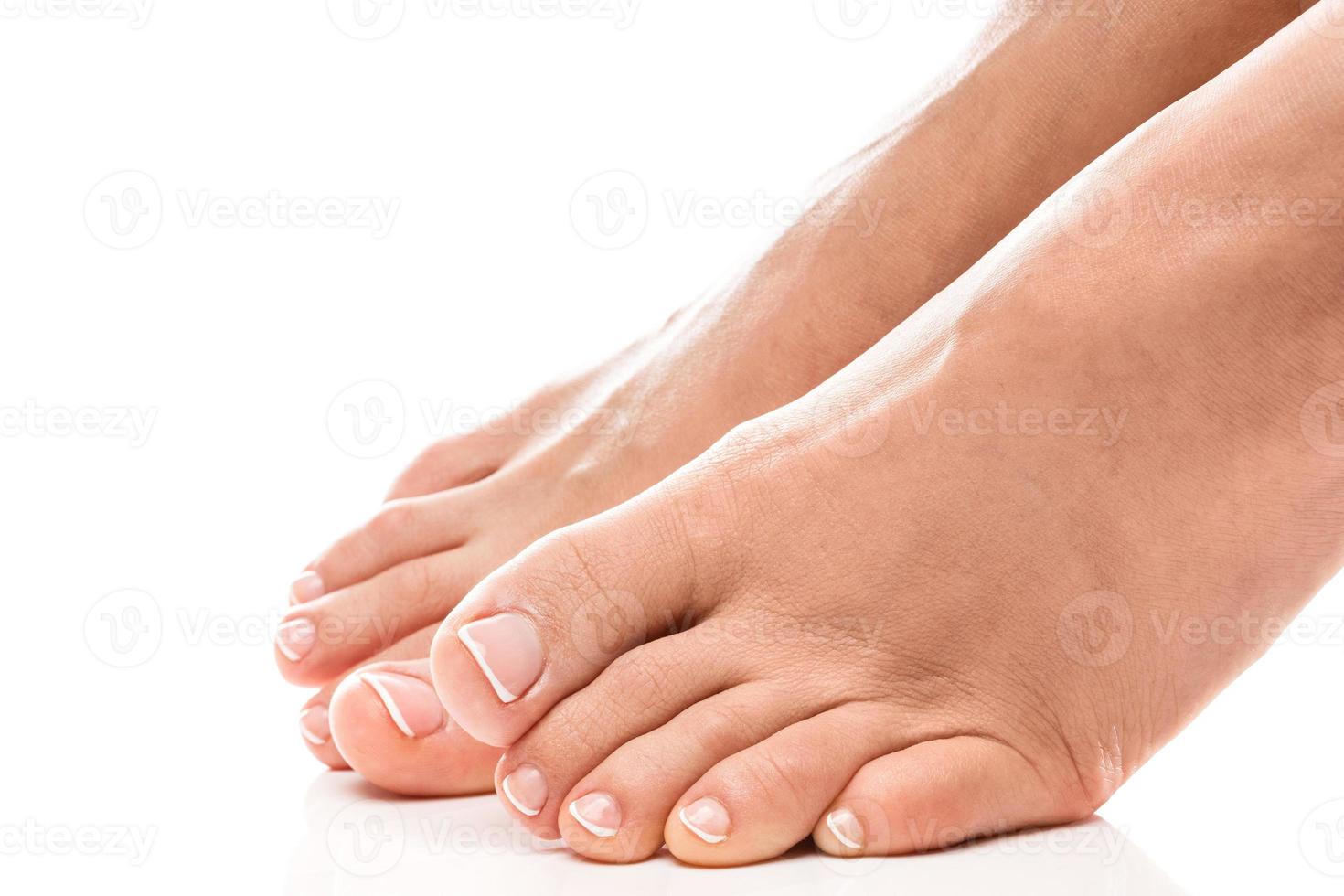 Female feet with soft skin and french pedicure on white background photo