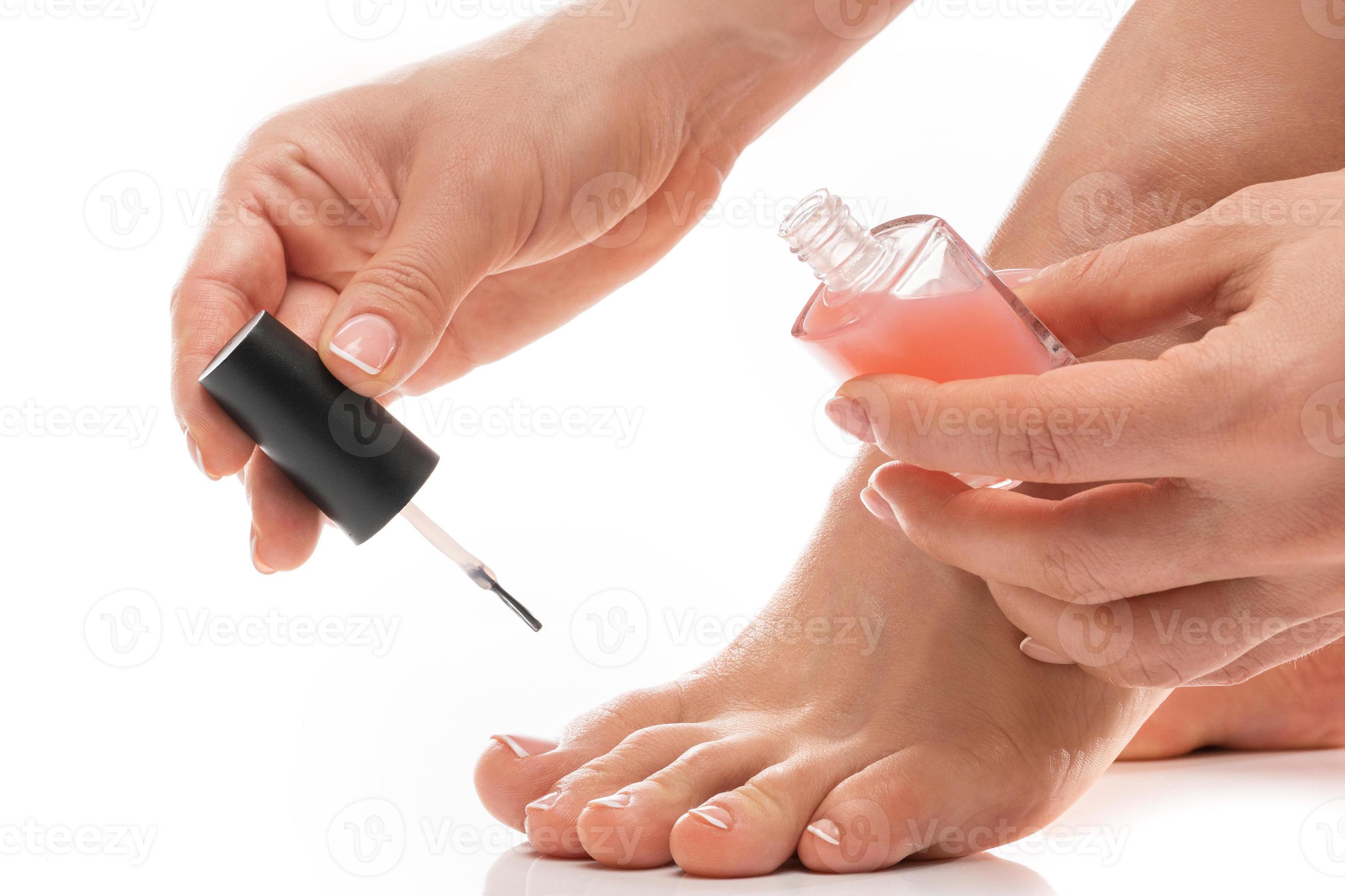 Female foot with beautiful french pedicure. Woman applying pink nail