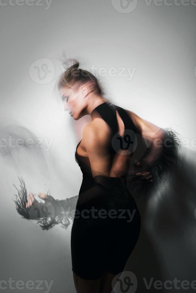 Portrait of dancing woman wearing long tulle gloves taken with a long exposure for motion blur effect photo