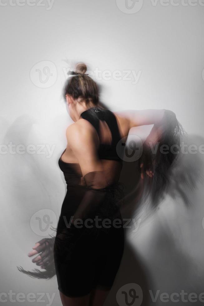 Portrait of dancing woman wearing long tulle gloves taken with a long exposure for motion blur effect photo