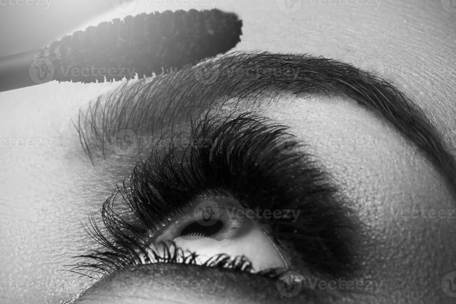 Female eye with beautiful long lashes and mascara wand photo