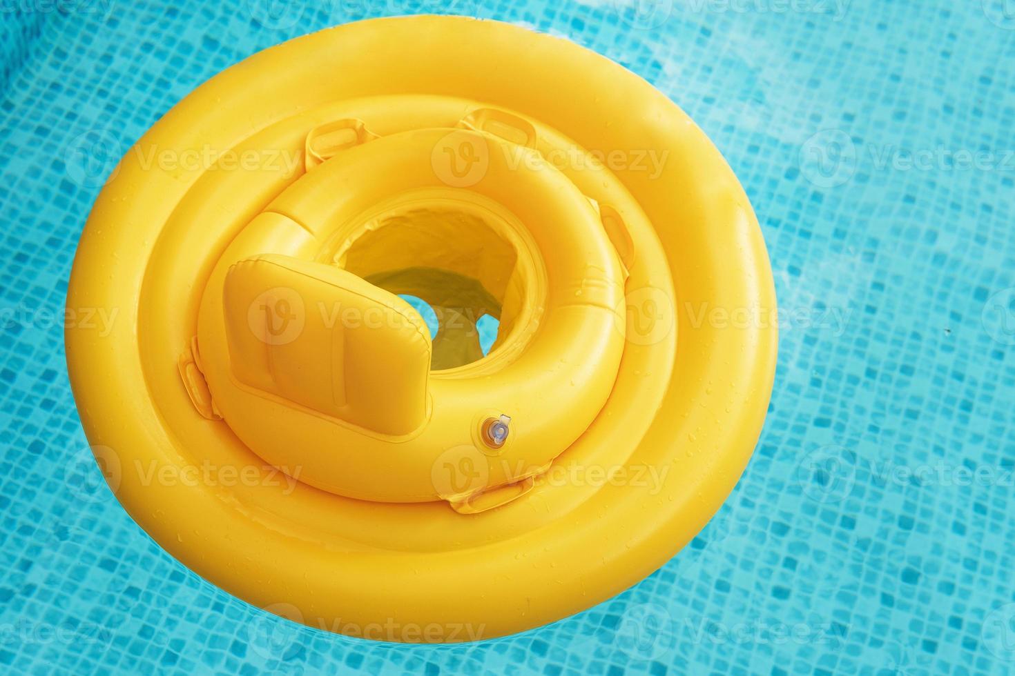 Inflatable baby float ring in open-air swimming pool photo