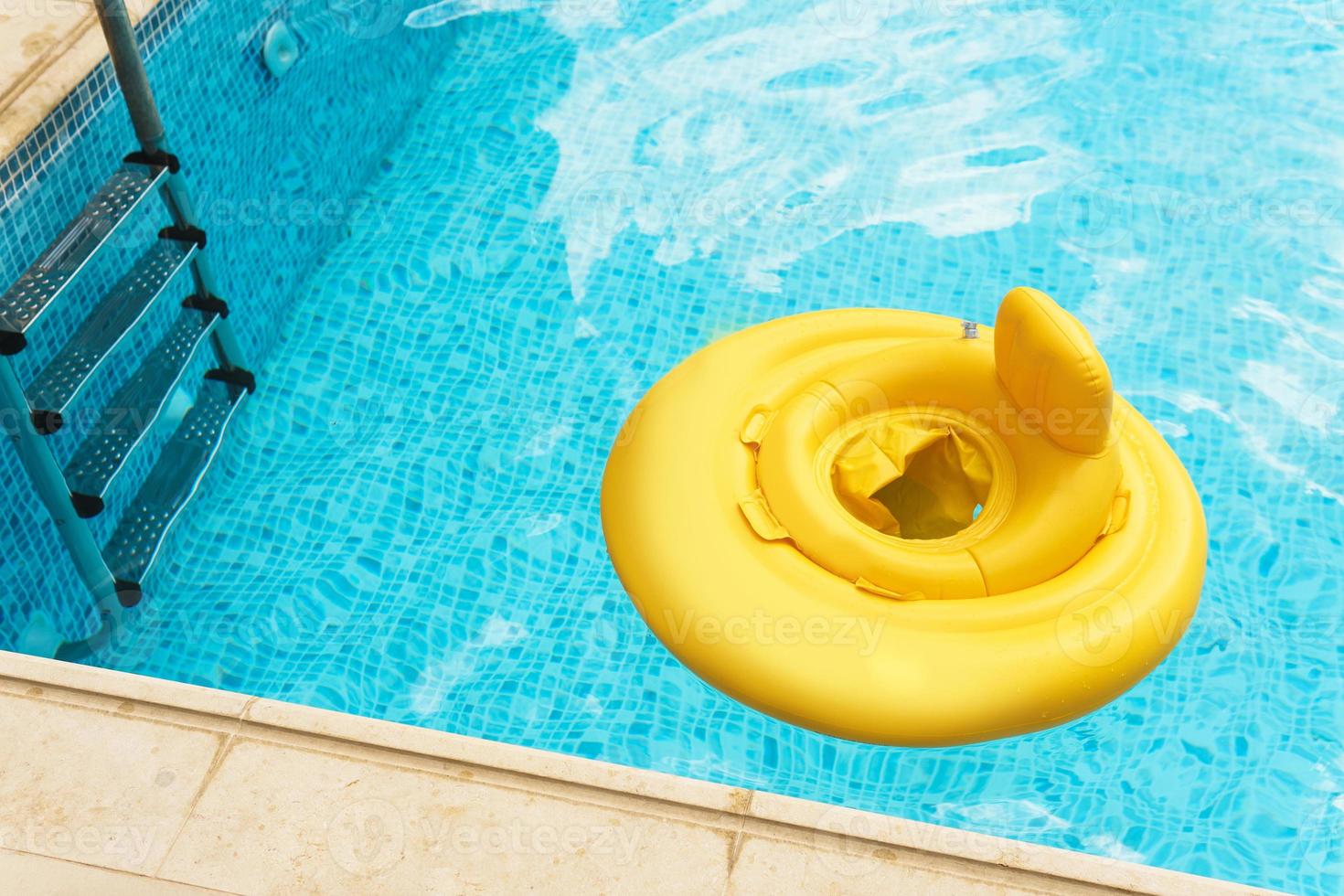 Inflatable baby float ring in open-air swimming pool photo