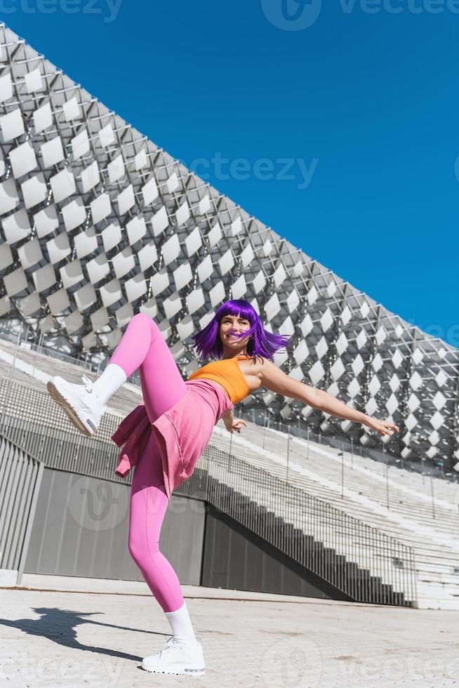 Carefree active woman dancer wearing colorful sportswear having fun on the street photo