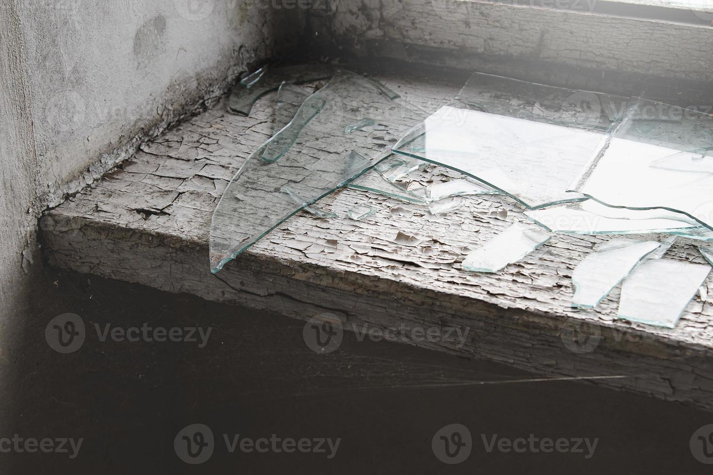Windowsill with spider web and broken glass in abandoned building. photo