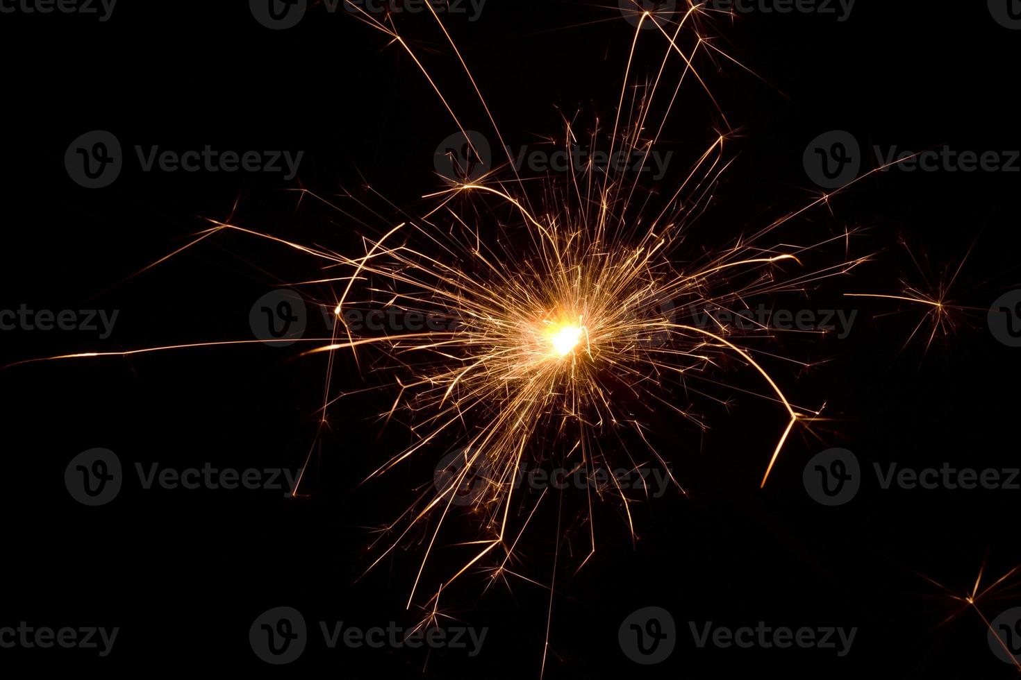 New years eve celebration with sparkling fireworks. Sparklers on a black background. Close-up of the burning spark. Fireworks in flames on a black background. Christmas sparklers. photo