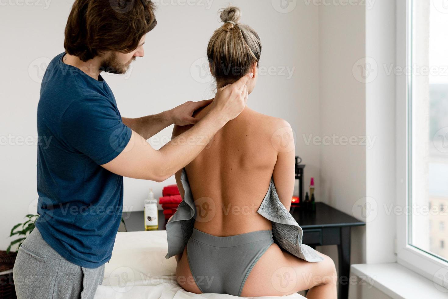 Professional masseur using acupressure techniques for client's neck massage photo