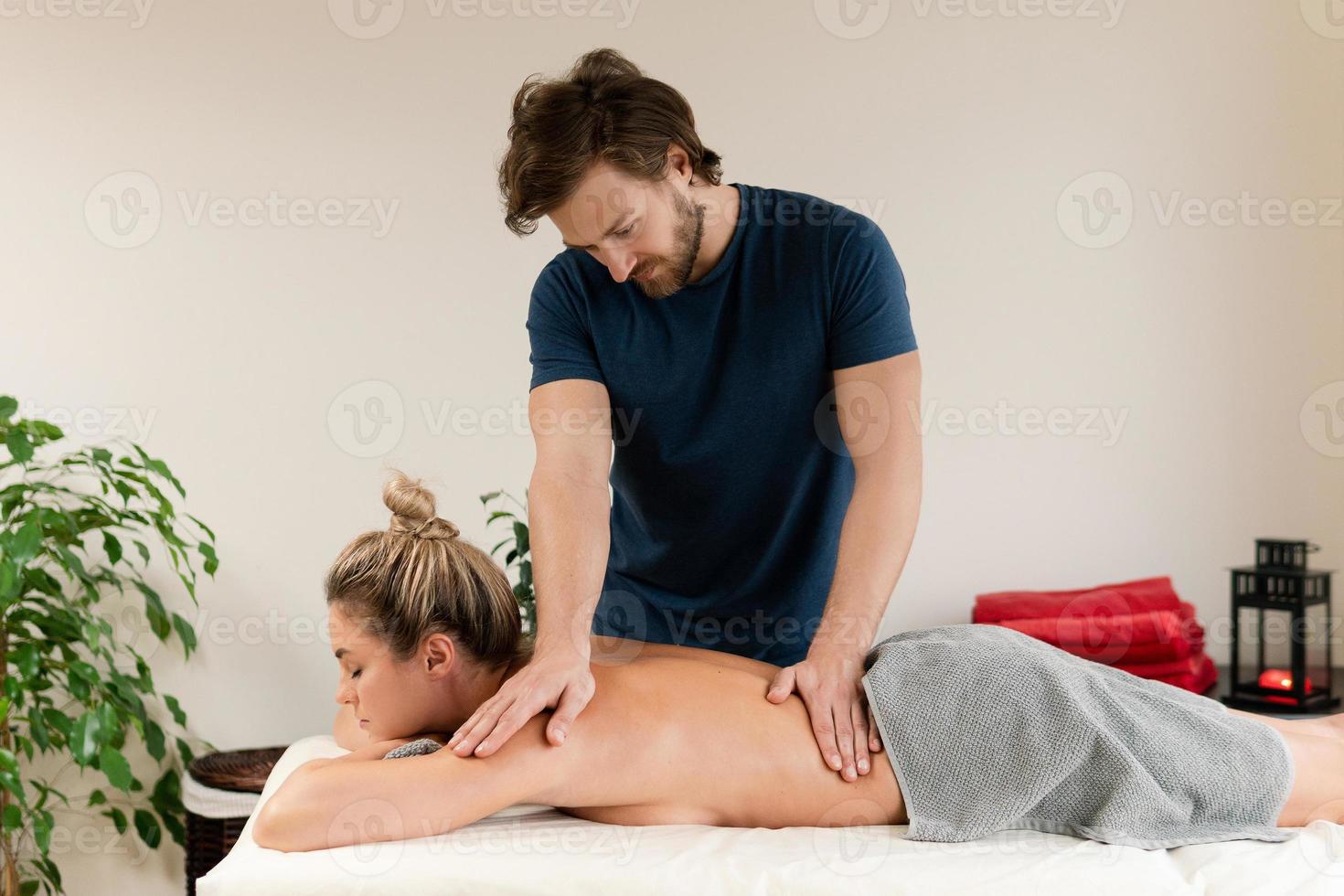 Masseur man doing back massage for his client photo